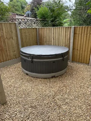 a circular circular table in front of a fence at Dinas Lodge with private hot tub in Llangollen