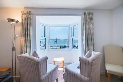 a living room with two chairs and a window at Fabulous Sea View Apartment in Aberdyfi