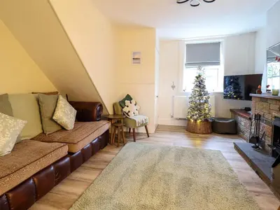 a living room with a couch and a christmas tree at Golygfa'r Orsaf Snowdonia National Park in Bala