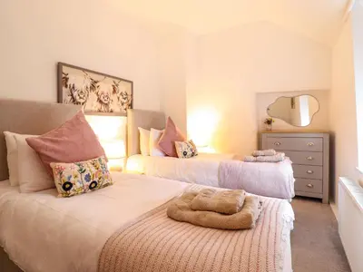 a bedroom with two beds and a dresser at Golygfa'r Orsaf Snowdonia National Park in Bala