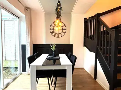 a dining room with a table and chairs and a clock at Shrewsbury Stayscape - Modern & Spacious 3BR - Family & Business Ready for 7 by Parydise Properties in Bicton