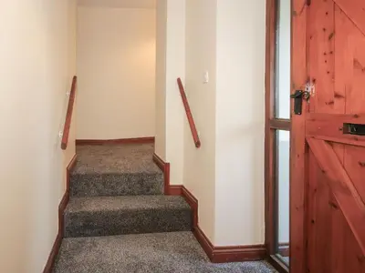 a stairway with a wooden door and a stair case at Walton Maisonette in Craven Arms
