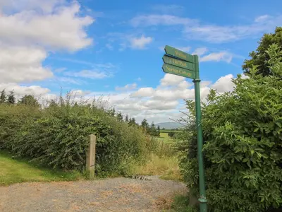 a green street sign on the side of a road at Walton Maisonette in Craven Arms