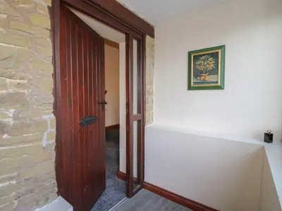 a wooden door in a room with a stone wall at Walton Maisonette in Craven Arms