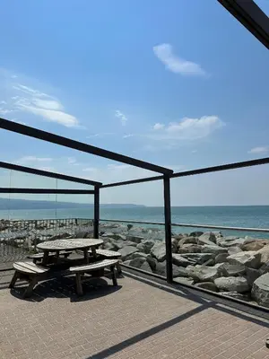 a picnic table on a patio overlooking the ocean at Lyons Sunnysands Caravan Park in Barmouth