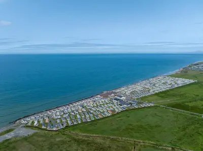 an aerial view of a town next to the ocean at Lyons Sunnysands Caravan Park in Barmouth