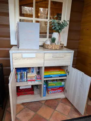 a wooden table with a book shelf with books at Thistledonia in Trawsfynydd