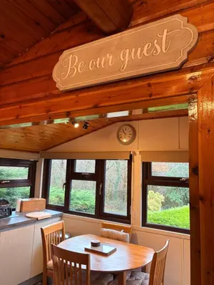 a dining room with a table and a sign that reads be our guest at Thistledonia in Trawsfynydd