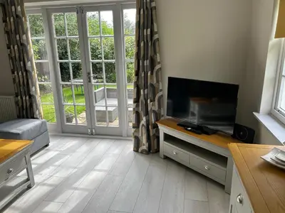 a living room with a flat screen tv sitting on a table at Dog & Family Friendly Private Cottage in Orleton in Orleton