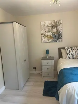 a bedroom with a bed and a painting on the wall at Dog & Family Friendly Private Cottage in Orleton in Orleton