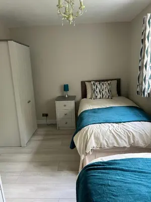 a bedroom with a bed and a chandelier at Dog & Family Friendly Private Cottage in Orleton in Orleton