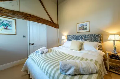 a bedroom with a bed with a teddy bear on it at The Garden Cottage in Craven Arms