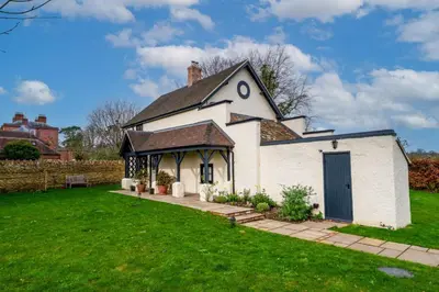 a small white building with a black roof at The Garden Cottage in Craven Arms