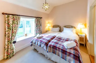 a bedroom with two beds and a window at The Garden Cottage in Craven Arms