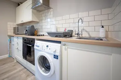a kitchen with a washing machine and a sink at Modern Town Centre Apartment in Leominster