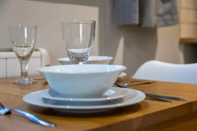 a wooden table with a bowl and a glass on it at Modern Town Centre Apartment in Leominster