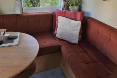 a living room with a couch and a table at 3 Bed Caravan - Sleeps 6 - Pets - Parking - Wifi in Borth