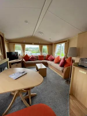 a living room with a couch and a table at The Perfect Escape 2 Bedroom Static Caravan Pet Friendly in Aberystwyth
