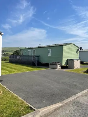 a large green building next to a parking lot at The Perfect Escape 2 Bedroom Static Caravan Pet Friendly in Aberystwyth