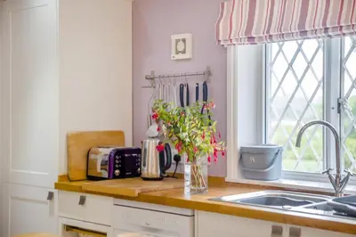 a kitchen counter with a sink and a vase of flowers at 2 Bed in Woofferton oc-b29941 in Woofferton