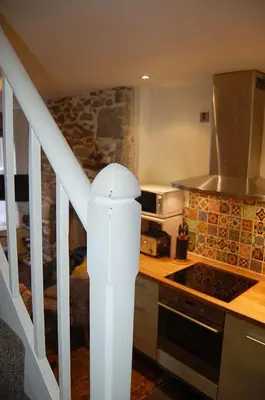 a kitchen with a staircase leading up to a bedroom at Cysgod Idris Cottage in Dolgellau