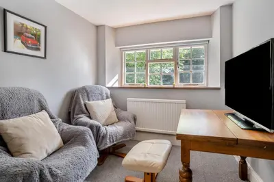 a living room with two chairs and a table and a tv at 3 Bed in Scethrog oc-h30013 in Scethrog