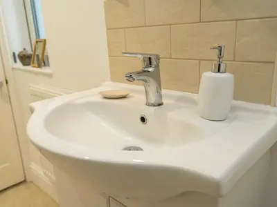 a white bathroom sink with a soap dispenser on it at Colourful homely 2 bed terrace - Pass the Keys in Shrewsbury