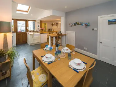 a kitchen and dining room with a wooden table and chairs at Colourful homely 2 bed terrace - Pass the Keys in Shrewsbury