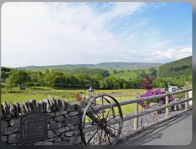 a stone fence with a stonewheel next to a stone wall at Awel Yr Mynydd in Ystrad Meurig