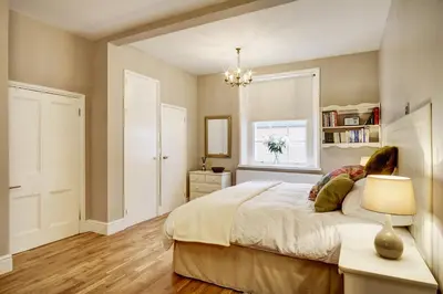 a bedroom with a bed with a lamp and a window at Ludwick Apartment in Shrewsbury