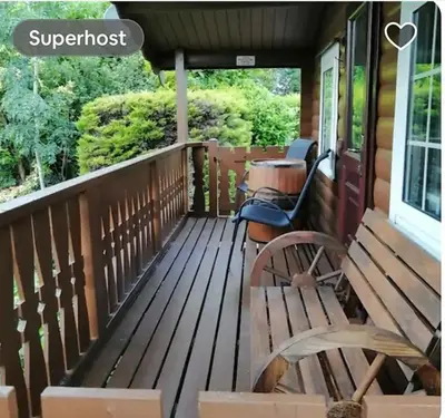 a front porch with a bench and a swing at Spyder Ranch in Trawsfynydd