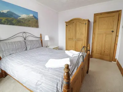 a bedroom with a large bed with a wooden frame at Tan Y Fron in Dyffryn