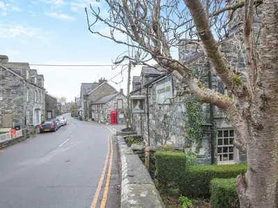 a street in an old town with a red phone booth at Isfryn in Llanbedr