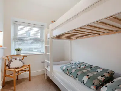 a bedroom with a bunk bed and a chair at Isfryn in Llanbedr