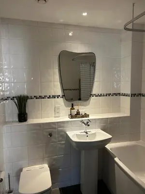 a bathroom with a sink and a toilet and a mirror at Luxury 2 bedroom town apartment in Aberystwyth
