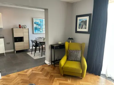 a living room with a yellow chair and a table at Luxury 2 bedroom town apartment in Aberystwyth