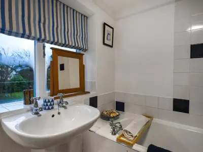 a bathroom with a sink and a bath tub at Sheldon Cottage in Bishops Castle