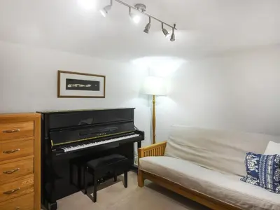 a bedroom with a piano next to a bed at Sheldon Cottage in Bishops Castle