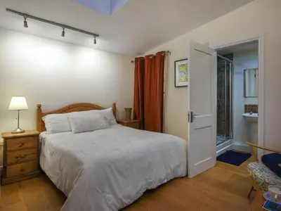 a bedroom with a bed and an open door at Sheldon Cottage in Bishops Castle