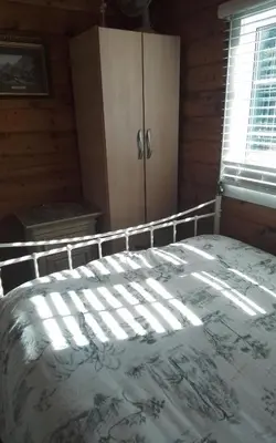a bedroom with a bed in a room with a window at Hamishs log cabin in Trawsfynydd