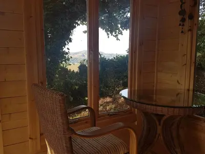 a porch with a table and chairs and a large window at Character cottage with spectacular views in Church Stoke