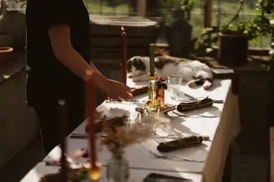 a person standing over a table with a dog laying behind it at River Cottage by Birch Stays in Glasbury