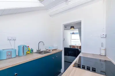 a kitchen with blue cabinets and a sink at Aberdovey Sea View Apartment in Aberdyfi