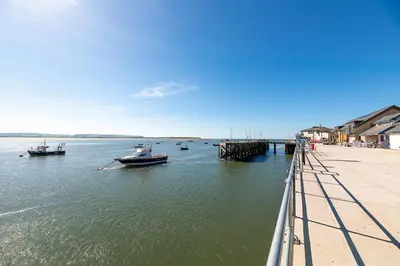 a group of boats in the water next to a beach at Aberdovey Sea View Apartment in Aberdyfi