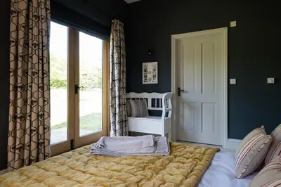 a bedroom with a large bed and a window at Welsh Border Escape- Perfect for families & groups in Clyro