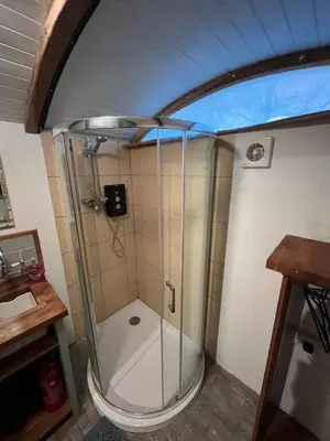 a shower with a glass door in a bathroom at The carriage in Three Cocks Junction