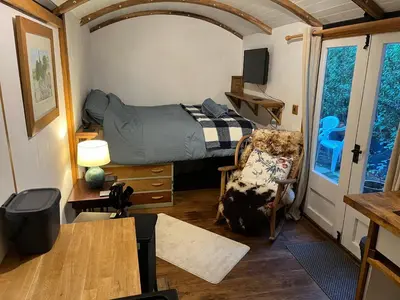 a bedroom with a bed in a tiny house at the railway carraige in Three Cocks Junction