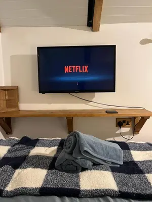 a flat screen tv sitting on top of a table at the railway carraige in Three Cocks Junction