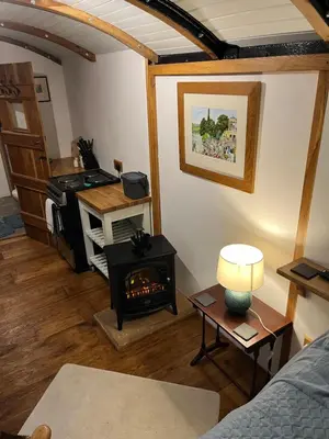a living room with a fireplace and a stove at the railway carraige in Three Cocks Junction