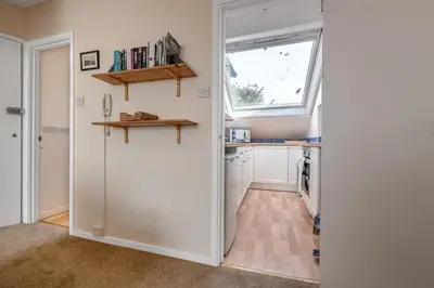 a kitchen with a door leading into a kitchen with a window at Beach Front flat in Aberdovey in Aberdyfi